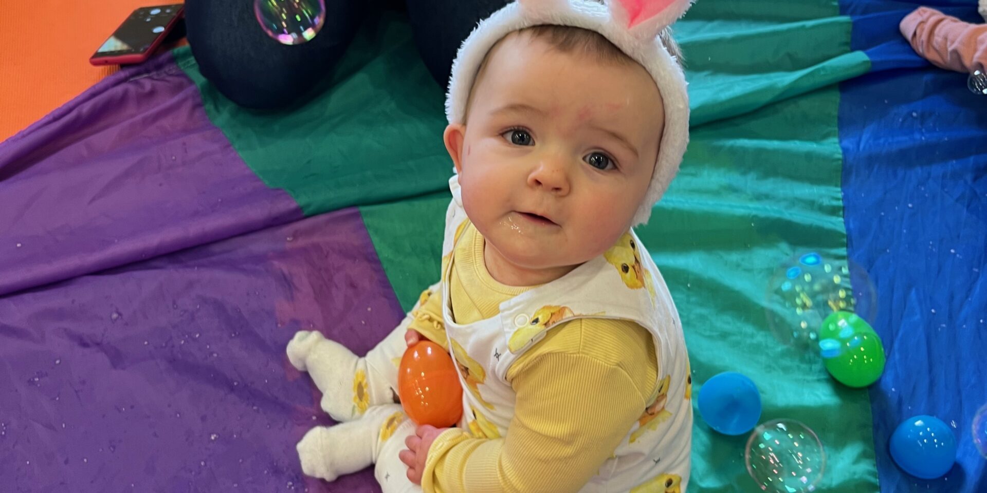 Sitting baby wearing bunny ears, easter holidays