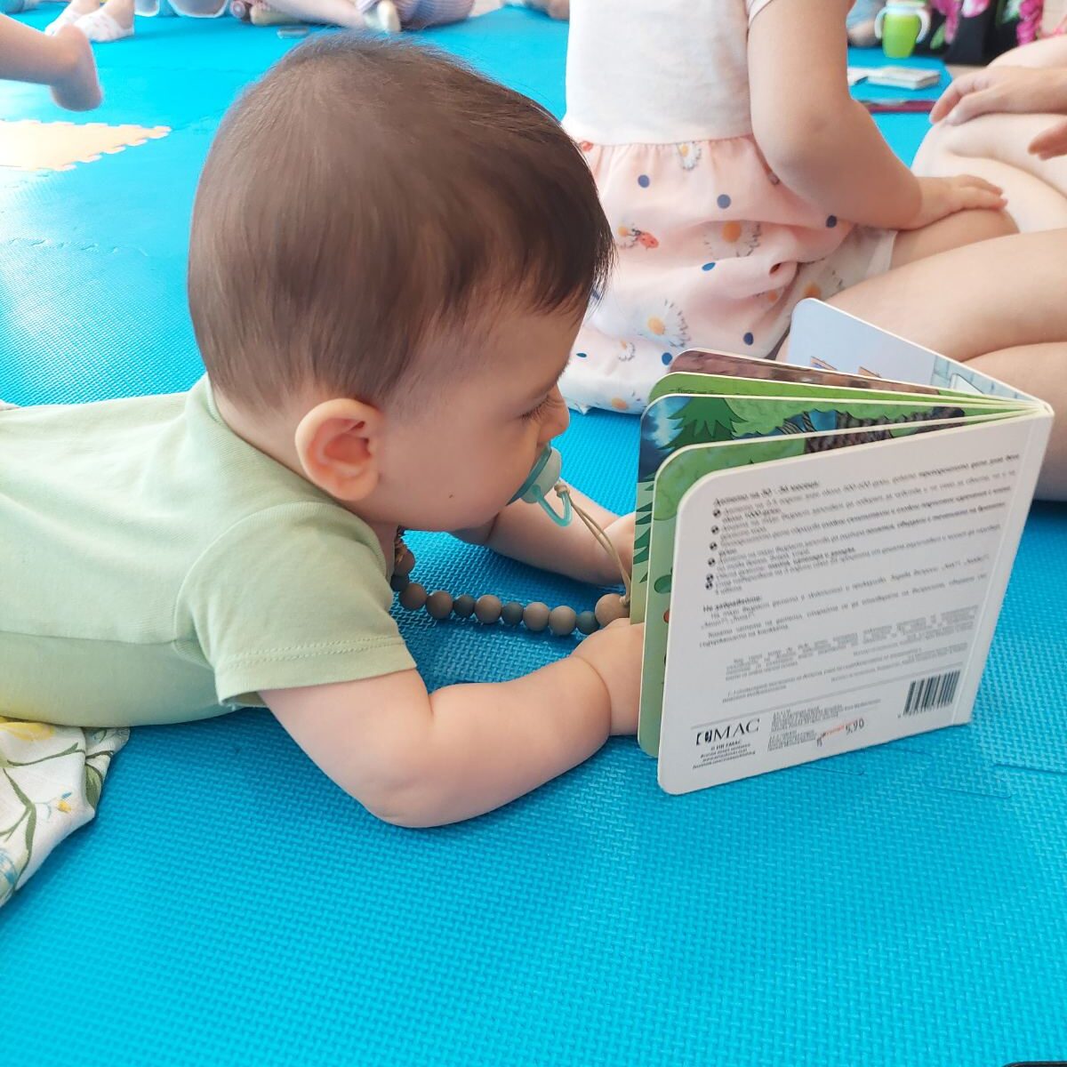 little boy with a book at a baby class